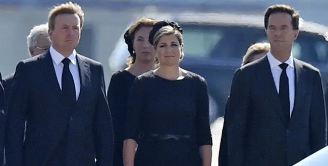 King Willem Alexander, his wife Maxima and prime minister Mark Rutte, from left, stand during a ceremony to mark the return of the first bodies, of passengers and crew killed in the downing of Malaysia Airlines Flight 17, from Ukraine at Eindhoven military air base, Netherlands, Wednesday, July 23, 2014