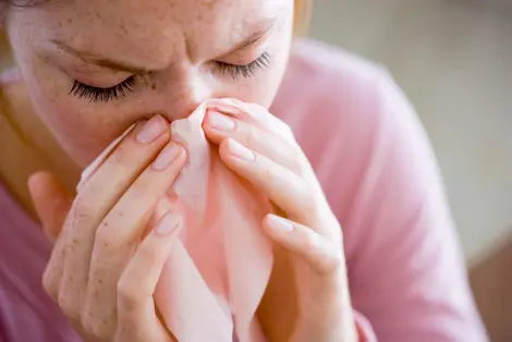Woman blowing nose
