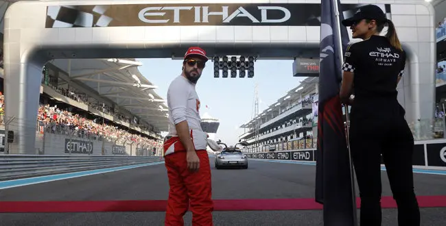 Ferrari driver Fernando Alonso looks around as he stands on track before the Emirates Formula One Grand Prix at the Yas Marina racetrack in Abu Dhabi, United Arab Emirates, Sunday, Nov. 23, 2014.