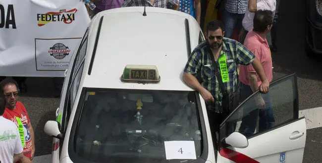 A taxi leads a demonstration during a 24 hour taxi strike and protest in Madrid, Spain, Wednesday, June 11, 2014. The taxi drivers were protesting against unregulated competition from private companies, in particular, Uber, an international company that puts people in contact with each other to share cars or pay for short journeys in private vehicles within the city.