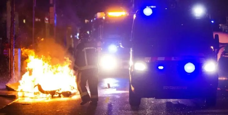 GRA505. BARCELONA, 25/05/2016.- Miembros del cuerpo de bomberos se han personado para apagar el fuego en los contenedores que han sido incendiados en la calle Gran de Gràcia de Barcelona, tras el tercer día de protestas por el desalojo del "banco expropiado", una antigua sucursal bancaria ocupada en 2011. EFE/Quique García.