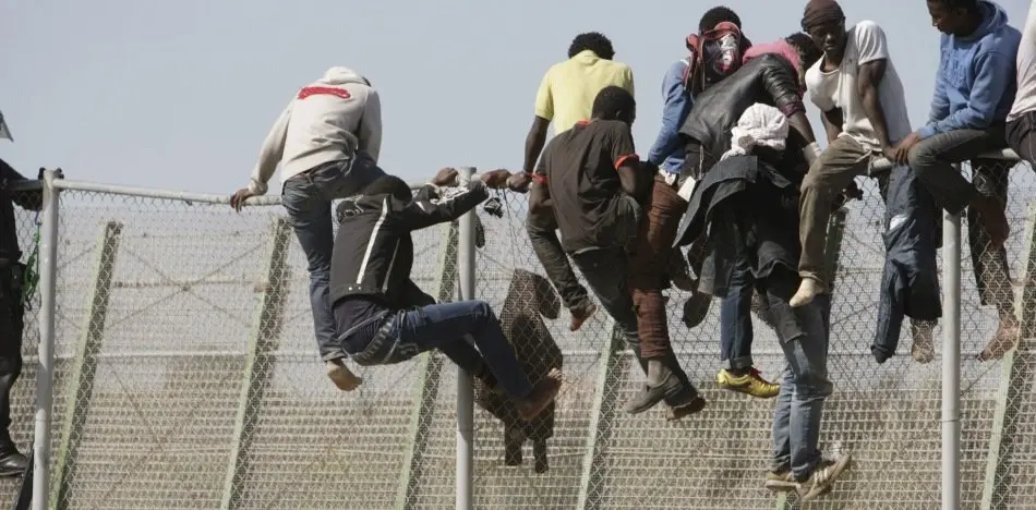 COMIENZAN A BAJAR DE VALLA DE MELILLA ALGUNOS DE LOS INMIGRANTES ENCARAMADOS