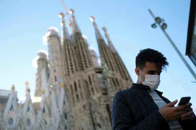 FILE PHOTO: A man wears a protective mask in front of Basilica Sagrada Familia, amid the novel coronavirus outbreak, in Barcelona, Spain February 2, 2020. REUTERS/Nacho Doce