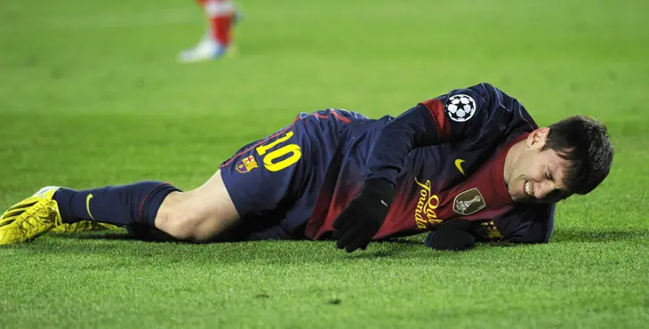 Barcelona's Lionel Messi reacts after picking up an injury while trying to score to goal against Benfica's goalkeeper Artur during their Champions League Group G soccer match at the Nou Camp stadium in Barcelona December 5, 2012. REUTERS/Sergio Carmona(SPAIN - Tags: SPORT SOCCER TPX IMAGES OF THE DAY)