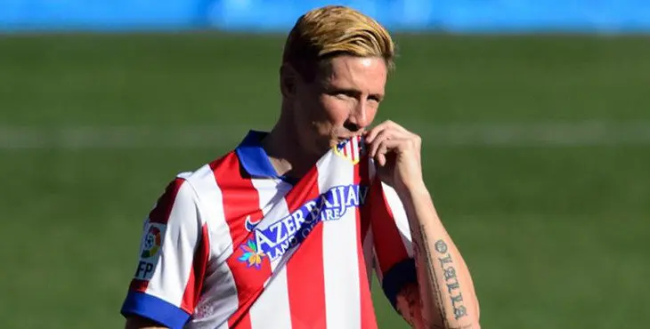 Atletico Madrid's new signing Spanish forward Fernando Torres kisses the shield on his jersey during his official presentation at the Vicente Calderon stadium in Madrid on January 4, 2015. AFP PHOTO / DANI POZO