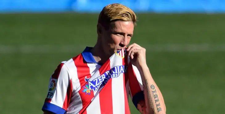 Atletico Madrid's new signing Spanish forward Fernando Torres kisses the shield on his jersey during his official presentation at the Vicente Calderon stadium in Madrid on January 4, 2015. AFP PHOTO / DANI POZO
