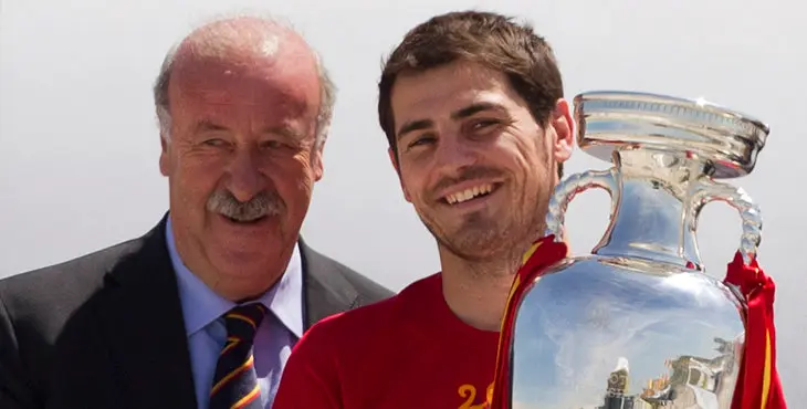 Spain's captain Iker Casillas, right walks from the plane holding the trophy alongside coach Vicente del Bosque, left on arrival at Barajasairport in Madrid Monday July 2, 2012.