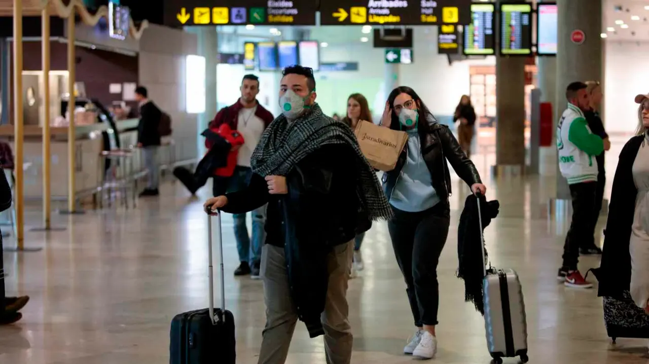 Travelers coming from Italy arrive at Manises airport with facial masks, in Valencia, eastern Spain, 25 February 2020. Two men who were recently in Milan are under inquiry at Vila-Real's Plana Hospital for a possible coronavirus infection. EFE/ Biel Alino