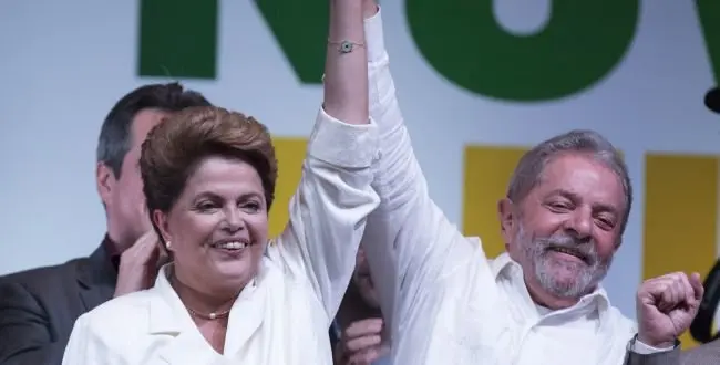 Brazil's President Dilma Rousseff celebrates with Brazils Former President Luiz Inacio Lula da Silva at a press conference in a hotel in Brasilia, Brazil, Sunday, Oct. 26, 2014. Official results showed Sunday that President Rousseff defeated opposition candidate Aecio Neves of the Brazilian Social Democracy Party, and was re-elected Brazil's president. (AP Photo/Eraldo Peres)