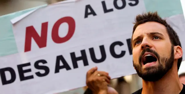 Demonstrators shout slogans in support of Juan Carlos Castano as they wait for the judicial commission to arrive to decide on his eviction, in Madrid July 27, 2012. Castano, 43, who came from his native Colombia to Spain in 2000, stopped making mortgage payments after becoming unemployed in late 2009. His eviction was suspended for another two months last minute due to ongoing negotiations with his bank. Sign reads, "No to evictions". REUTERS/Susana Vera (SPAIN - Tags: SOCIETY CIVIL UNREST BUSINESS) SPAIN/