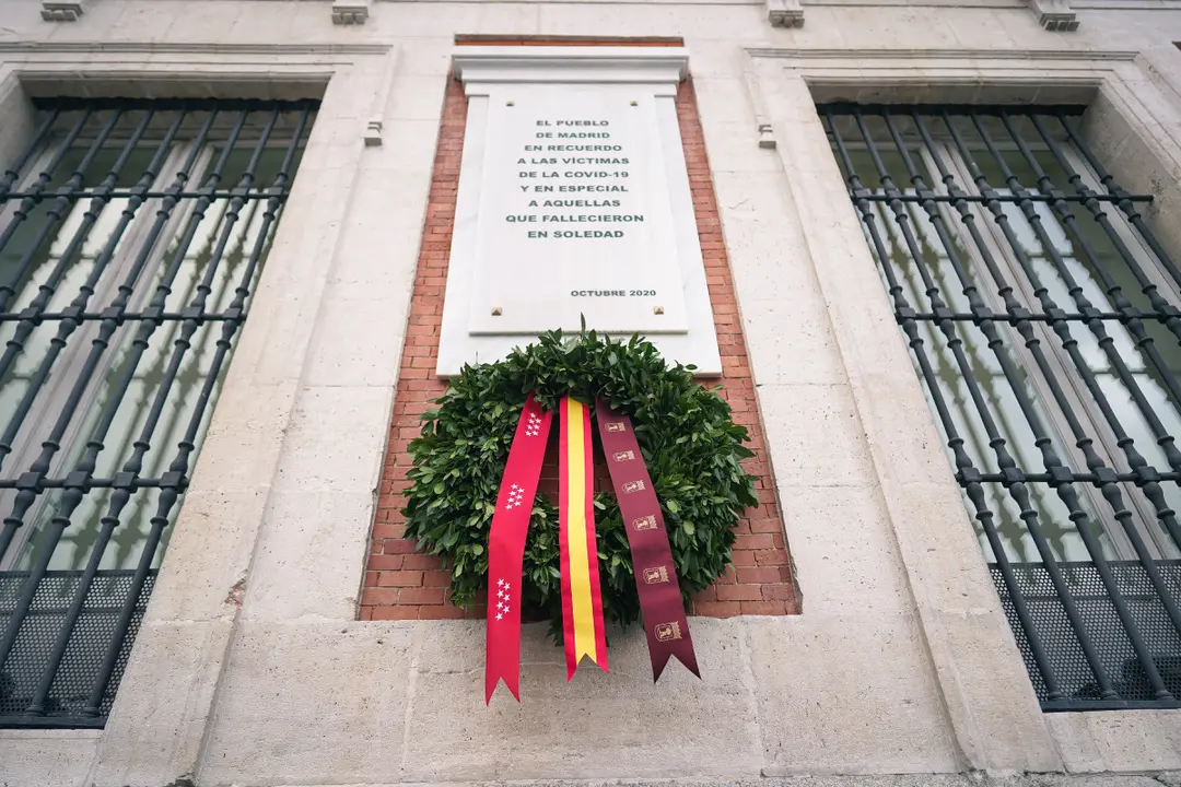 La Comunidad de Madrid coloca una corona de laurel en la placa que recuerda a las víctimas del COVID-19 en la Real Casa de Correos