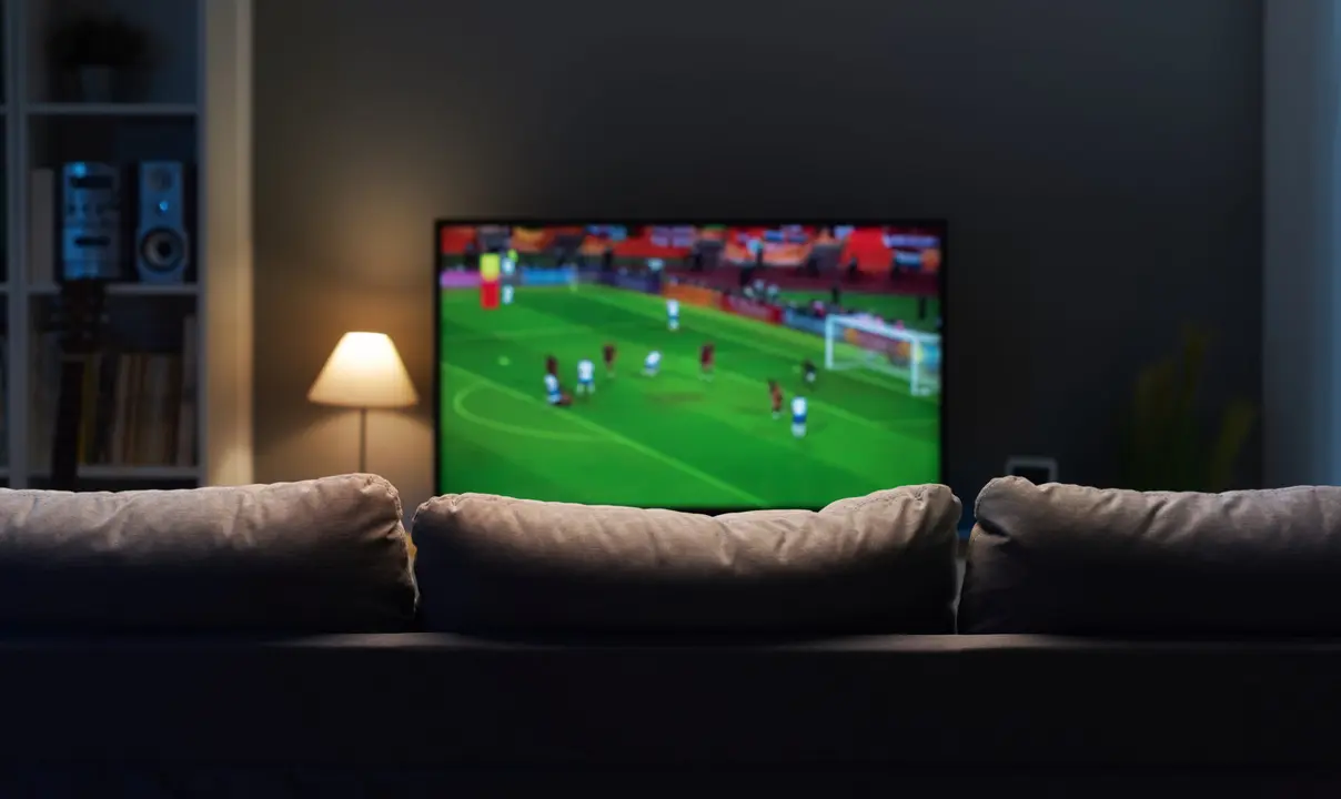 Football match on widescreen flat TV at home, sport and entertainment concept