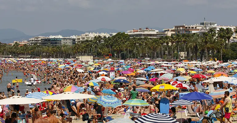 People relaxing and having fun on the beach of Salou, Spain