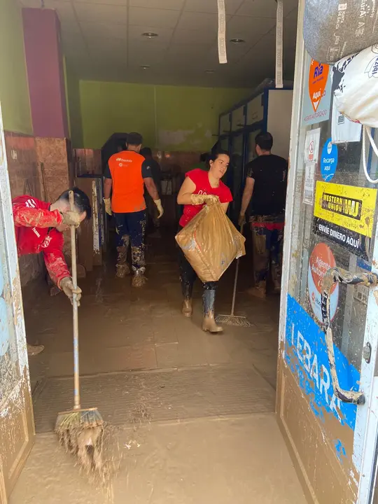 Voluntarios ayudan en las labores de limpieza de un pequeño comercio en La Torre