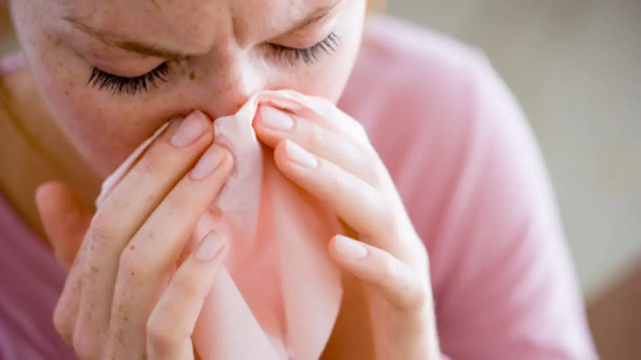Woman blowing nose