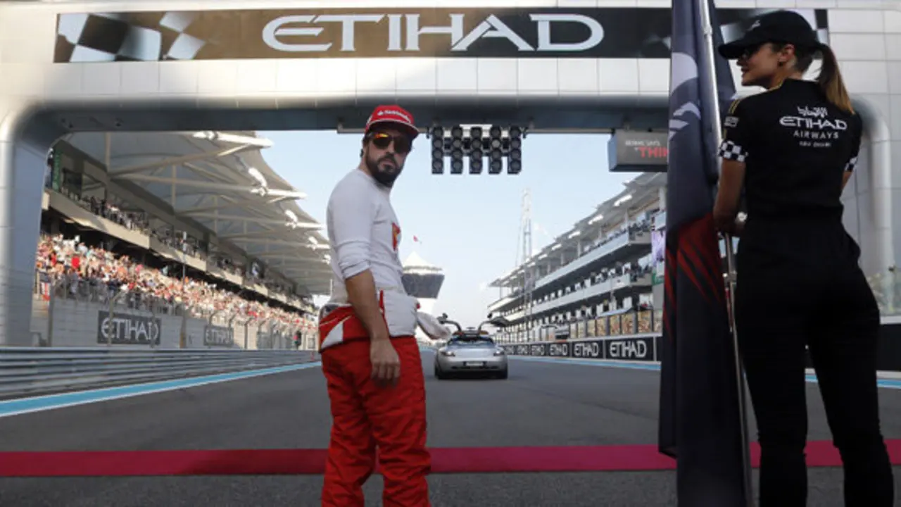 Ferrari driver Fernando Alonso looks around as he stands on track before the Emirates Formula One Grand Prix at the Yas Marina racetrack in Abu Dhabi, United Arab Emirates, Sunday, Nov. 23, 2014.