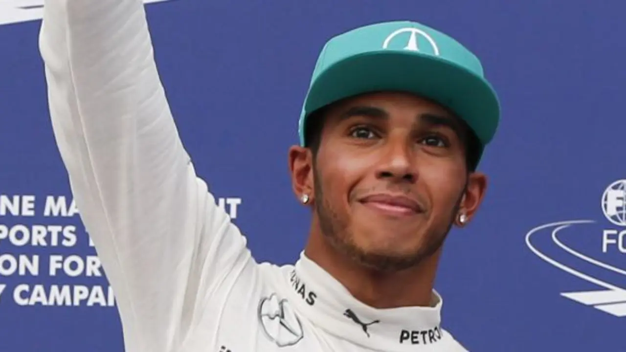Mercedes driver Lewis Hamilton of Britain  waves after pose for photos after qualifying for the Malaysian Formula One Grand Prix at Sepang International Circuit in Sepang, Malaysia, Saturday, March 29, 2014. Hamilton took pole position for the Malaysian Grand Prix on Saturday to tie the record for most qualifying wins by a British driver in Formula One. (AP Photo/Vincent Thian)