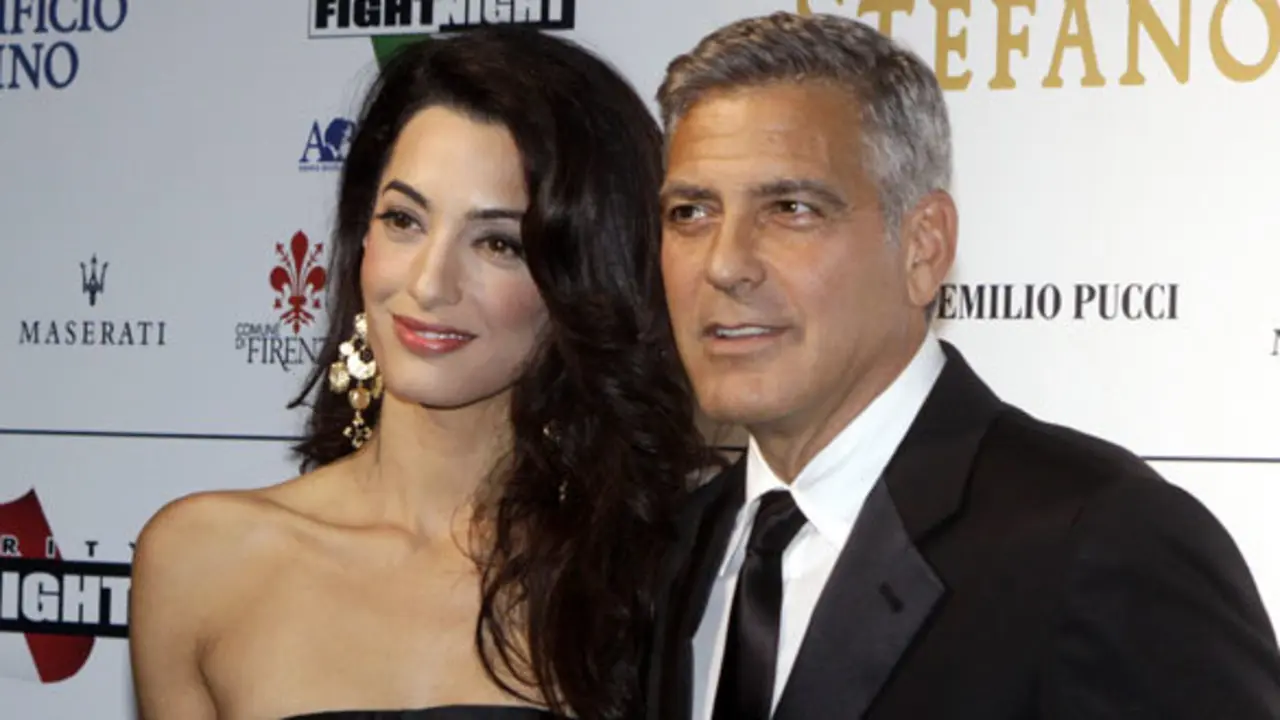 George Clooney and his fiancee Amal Alamuddin pose for photographers as they arrive for the "Celebrity Fight Night" foundation gala dinner, in Florence, Italy, Sunday, Sept. 7, 2014. (AP Photo/Francesco Bellini)