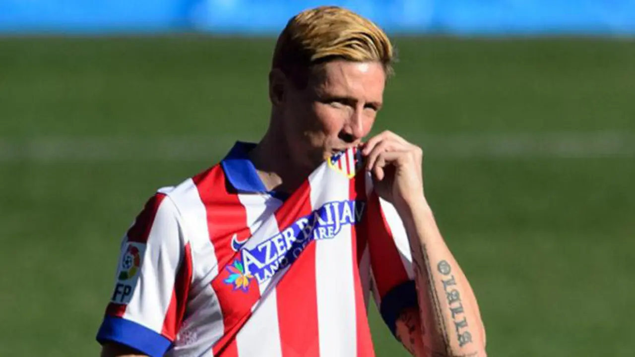 Atletico Madrid's new signing Spanish forward Fernando Torres kisses the shield on his jersey during his official presentation at the Vicente Calderon stadium in Madrid on January 4, 2015.  AFP PHOTO / DANI POZO