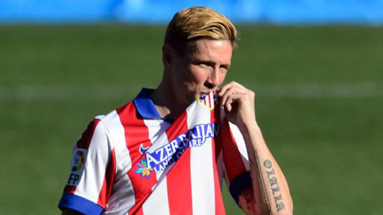 Atletico Madrid's new signing Spanish forward Fernando Torres kisses the shield on his jersey during his official presentation at the Vicente Calderon stadium in Madrid on January 4, 2015.  AFP PHOTO / DANI POZO