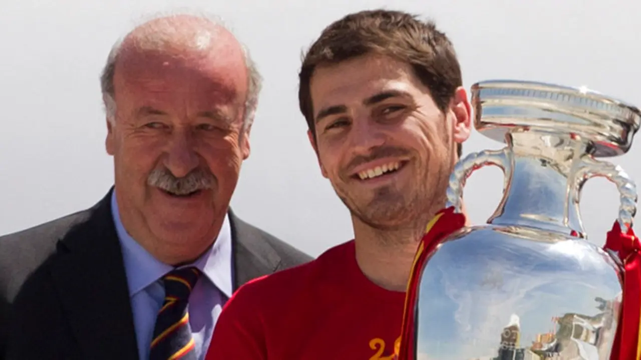 Spain's captain Iker Casillas, right walks from the plane holding the trophy alongside coach Vicente del Bosque, left on arrival at Barajasairport in Madrid Monday July 2, 2012.