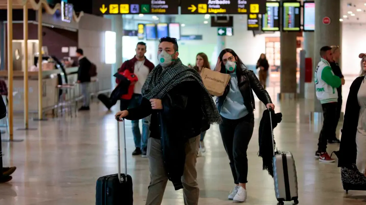 Travelers coming from Italy arrive at Manises airport with facial masks, in Valencia, eastern Spain, 25 February 2020. Two men who were recently in Milan are under inquiry at Vila-Real's Plana Hospital for a possible coronavirus infection. EFE/ Biel Alino