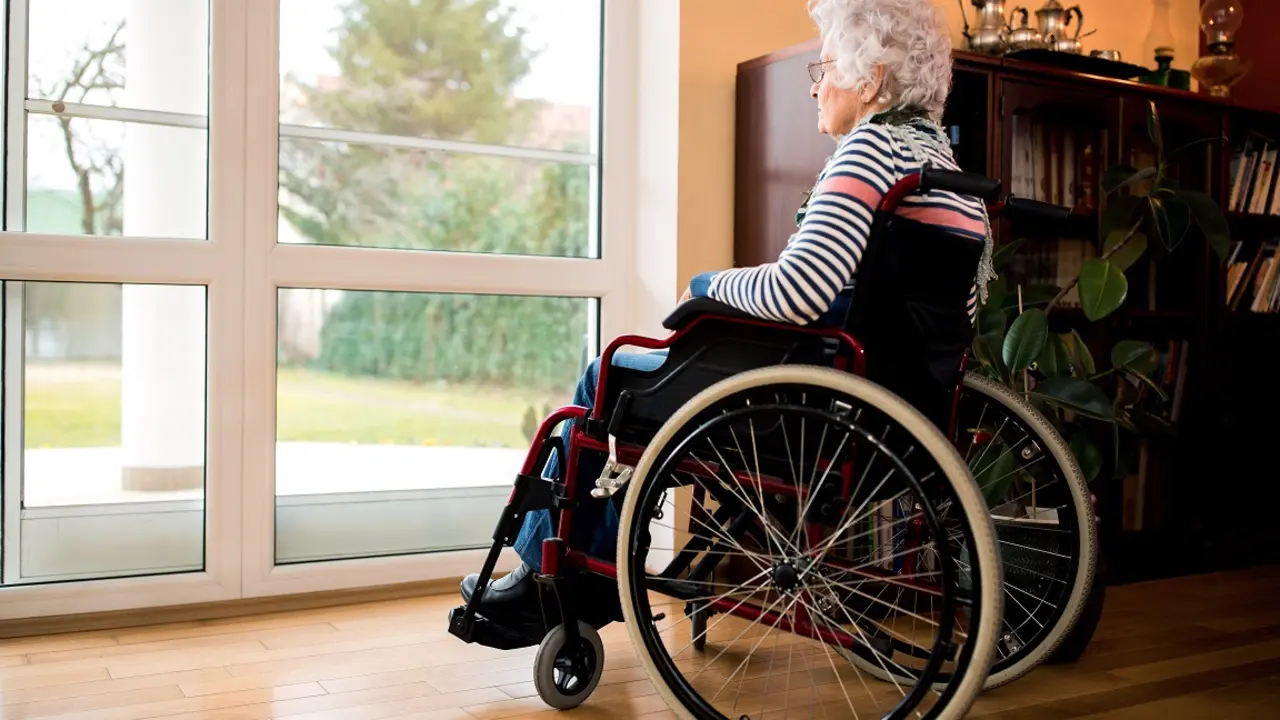 Loneliness senior woman sitting in wheelchair at nursing home, forgotten by the family