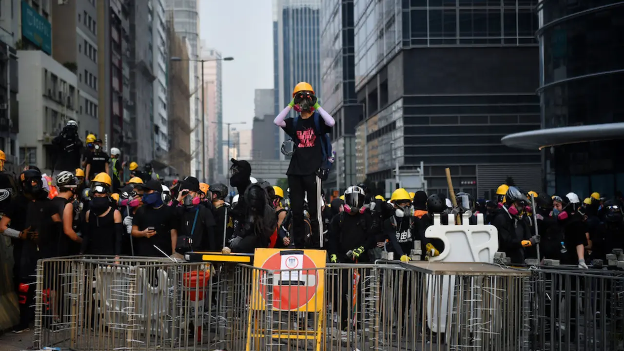 Protesters face off with riot police at Kowloon Bay in Hong Kong on August 24, 2019, in the latest opposition to a planned extradition law that has since morphed into a wider call for democratic rights in the semi-autonomous city. - Hong Kong riot police on August 24 fired tear gas and baton-charged protesters who retaliated with a barrage of stones, bottles and bamboo poles, as a standoff in a working-class district descended into violence. (Photo by Lillian SUWANRUMPHA / AFP)