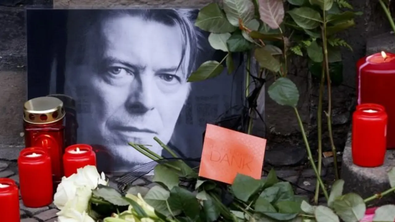 Flowers and lit candles are pictured next to a portrait of David Bowie outside the apartment house where he was living in 1976-78 in Berlin's Schoeneberg district, Germany, January 11, 2016. David Bowie, a music legend who used daringly androgynous displays of sexuality and glittering costumes to frame legendary rock hits "Ziggy Stardust" and "Space Oddity", has died of cancer aged 69.    REUTERS/Fabrizio Bensch  TPX IMAGES OF THE DAY