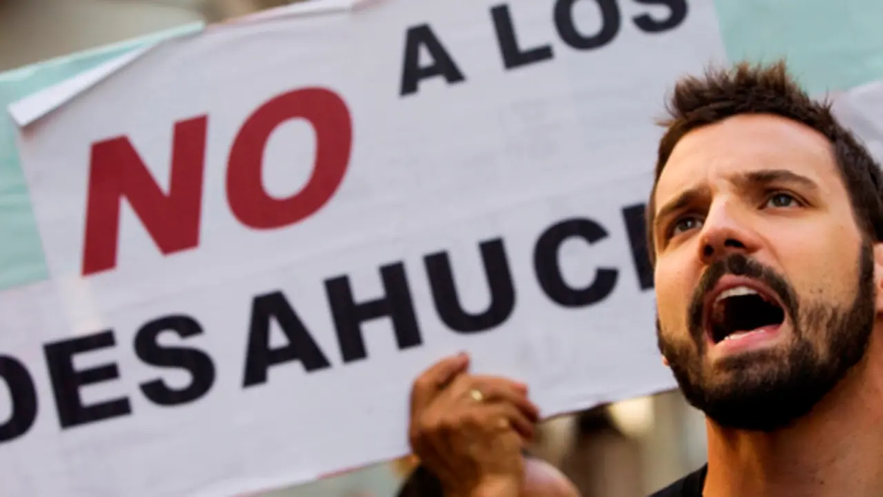 Demonstrators shout slogans in support of Juan Carlos Castano as they wait for the judicial commission to arrive to decide on his eviction, in Madrid July 27, 2012. Castano, 43, who came from his native Colombia to Spain in 2000, stopped making mortgage payments after becoming unemployed in late 2009. His eviction was suspended for another two months last minute due to ongoing negotiations with his bank. Sign reads, "No to evictions". REUTERS/Susana Vera (SPAIN - Tags: SOCIETY CIVIL UNREST BUSINESS) SPAIN/