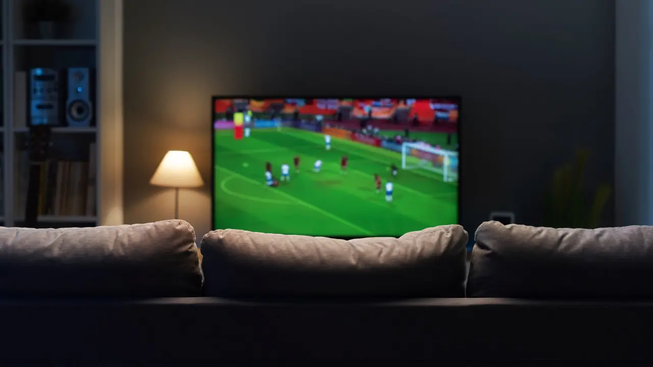 Football match on widescreen flat TV at home, sport and entertainment concept