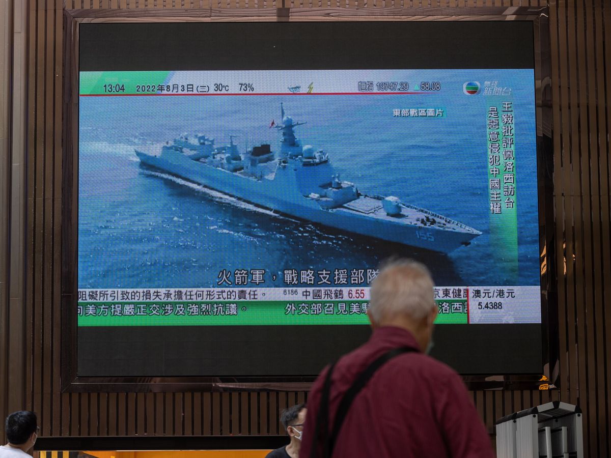 Un hombre mira las noticias tras la demostración de poder de China. Guerra Fría entre EEUU y China 